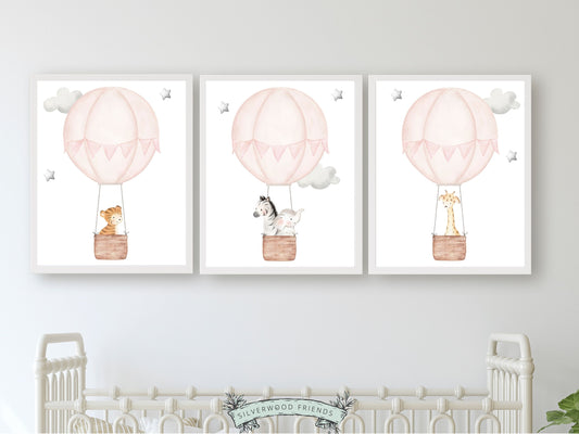 Let their imagination soar with our Pink Hot Air Balloon Nursery Prints featuring watercolour safari animals in pink hot air balloon's floating amongst grey stars and clouds.