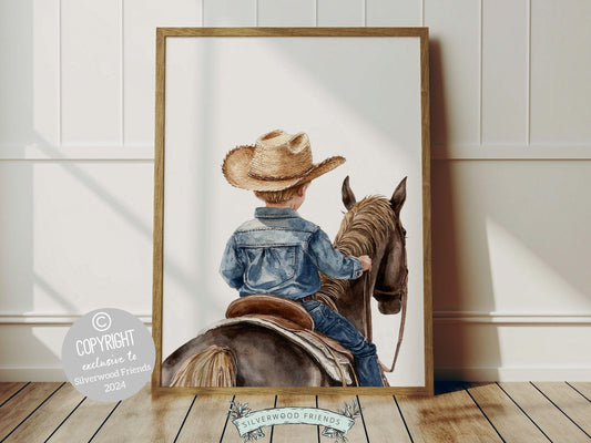 Cowboy Nursery Print, featuring an adorable little blonde cowboy riding his trusty horse. Perfect for western themed decor and a thoughtful cowboy baby shower gift for horse loving families.