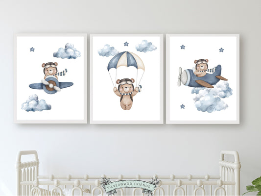 This delightful Set of 3 Teddy Bear Nursery Prints by Silverwood Friends, showcases adorable watercolour teddy bears embarking on adventures amidst a dreamy star-studded sky, flying airplanes and skydiving through fluffy clouds.